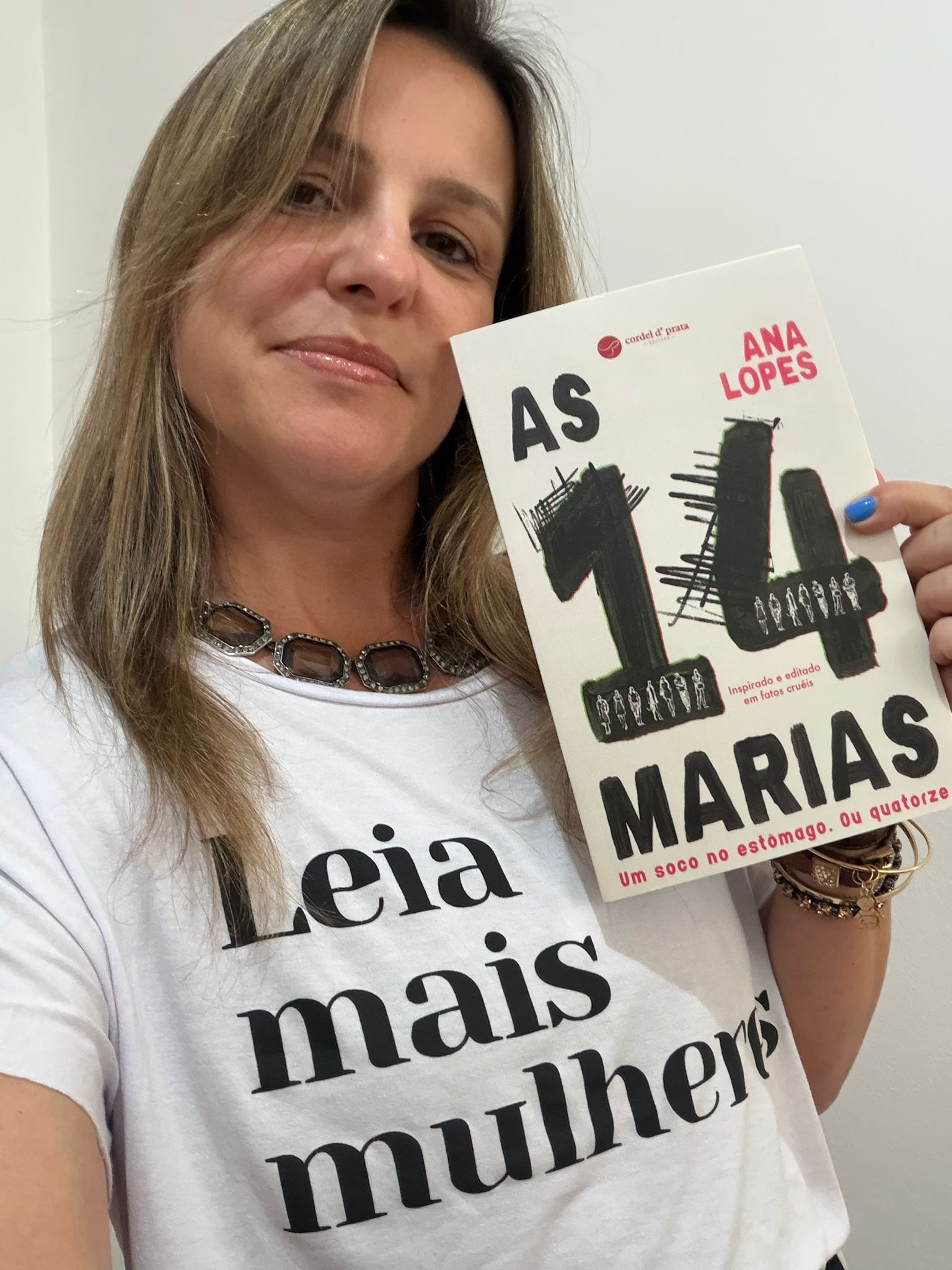 Ana Lopes segurando o livro As 14 Marias